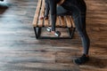 Sporty strong woman in black sportswear with sneakers doing exercises with dumbbells on a bench in the gym Royalty Free Stock Photo