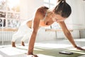 Sporty sunburn woman doing push-ups on fitness mat and using smartphone for counts results in fitness app Royalty Free Stock Photo