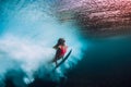 Sporty surfer woman dive underwater with under barrel wave