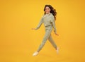 Sporty teenager child wearing a casual sport look. Cute teen girl in sports suit posing over yellow background. Royalty Free Stock Photo