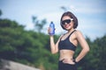 Sporty woman asin drinking water outdoor  after running on sunny day Royalty Free Stock Photo
