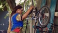 Sporty woman assessing damaged bicycle