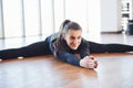 Sporty woman in black sportswear lying down on the floor by doing stretching Royalty Free Stock Photo