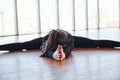 Sporty woman in black sportswear lying down on the floor by doing stretching Royalty Free Stock Photo