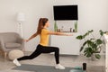 Sporty Woman With Braids Doing Forward Lunge Stretch At Home Royalty Free Stock Photo