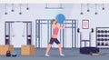 Sporty woman doing crossfit exercises with medicine leather ball girl training cardio workout concept modern gym health