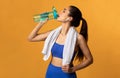 Sporty woman drinking mineral water from bottle at studio Royalty Free Stock Photo