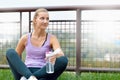 Sporty woman drinking in park after jogging