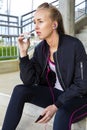 Sporty Woman Eating Protein Bar While Listening Music On Steps Royalty Free Stock Photo