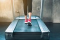 Sporty woman exercise running on treadmill machine in fitness gym., Close-up of runner shoes on track, Fitness and healthy