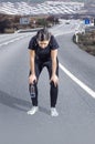 Sporty woman exhausted in a road after the run. Royalty Free Stock Photo