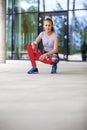 Sporty Woman Holding Water Bottle While Crouching On Footpath Royalty Free Stock Photo