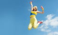 Sporty woman jumping with dumbbells. Funny woman in sportswear on sky background. Dynamic movement. Sport and healthy