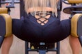 Sporty woman making exercise for legs, booty on training machine, closeup.