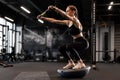 Sporty woman making squats on balance trainer. Royalty Free Stock Photo