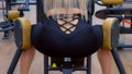 Sporty woman making exercise for legs, booty on training machine, closeup.