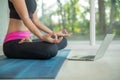 Sporty woman practicing yoga, doing ardha padmasana exercise, meditating in lotus pose, working out Royalty Free Stock Photo