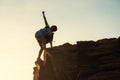 Sporty woman raise hand at mountain peak