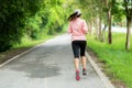 Sporty Woman runner running through the road. Workout in a Park. Outdoor Workout in a Park. Royalty Free Stock Photo