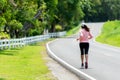 Sporty Woman runner running through the road. Workout in a Park. People workout outdoor  in a nature Park Royalty Free Stock Photo