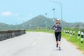 Sporty Woman runner running through the road. Workout in a Park. Royalty Free Stock Photo