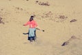 Sporty woman running down volcanic slope lifting dust trail.