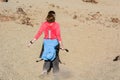 Sporty woman running down volcanic slope lifting dust trail.