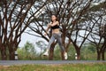 Sporty woman running and jumping in park Royalty Free Stock Photo