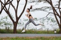 Sporty woman running and jumping in park Royalty Free Stock Photo