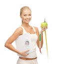 Sporty woman with scale, apple and measuring tape Royalty Free Stock Photo