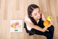 Sporty woman with scale and green apple and orange Royalty Free Stock Photo