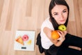 Sporty woman with scale and green apple and orange Royalty Free Stock Photo