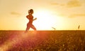 Sporty woman at sunset in wheat field Royalty Free Stock Photo