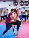 Sporty woman with trainer are doing self-defence moves in gym Royalty Free Stock Photo