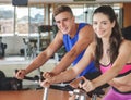 sporty woman using cycling exercise bike with her fitness partner