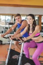 sporty woman using cycling exercise bike with her fitness partner