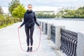 Sporty woman warming up with jump rope outdoors. Royalty Free Stock Photo