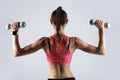 Sporty woman working out with weights. Back view Royalty Free Stock Photo