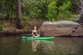 Sporty woman in yoga position on paddleboard, doing yoga on sup board, exercise for flexibility and stretching of Royalty Free Stock Photo