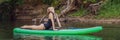 Sporty woman in yoga position on paddleboard, doing yoga on sup board, exercise for flexibility and stretching of Royalty Free Stock Photo