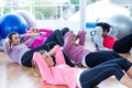 Sporty women doing sit ups on hardwood floor Royalty Free Stock Photo