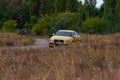 A sporty yellow sedan drives at high speed on an autumn paved ro Royalty Free Stock Photo