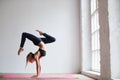 Sporty yogi girl practices yoga asana, Scorpion Pose Vrischikasana. Royalty Free Stock Photo