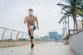 Sporty young asian man wearing face mask while jogging and running in park. Royalty Free Stock Photo