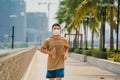 Sporty young asian man wearing face mask while jogging and running in park. Royalty Free Stock Photo