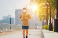 Sporty young asian man wearing face mask while jogging and running in park. Royalty Free Stock Photo