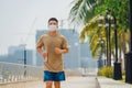 Sporty young asian man wearing face mask while jogging and running in park. Royalty Free Stock Photo