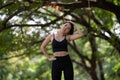 Young Asian woman doing stretching warm up before exercise outdoors in park, sport and healthy lifestyle concept