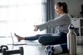 Sporty young Asian woman exercising at home, watching fitness video on Internet or having online fitness class Royalty Free Stock Photo