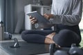 Sporty young Asian woman exercising at home, watching fitness video on Internet or having online fitness class Royalty Free Stock Photo